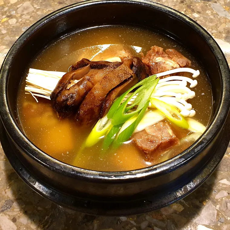 뼈없는 능이갈비탕. 맑은 국물에 갈비와 능이버섯, 대파가 담겨 있다.