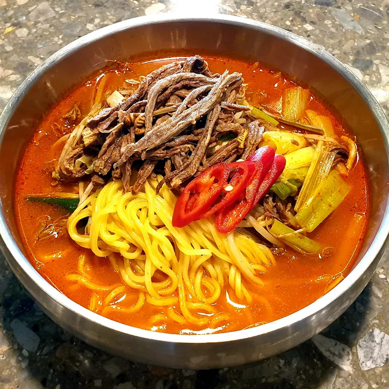 한우육개장칼국수. 육개장 국물에 칼국수 면이 담겨 있다.